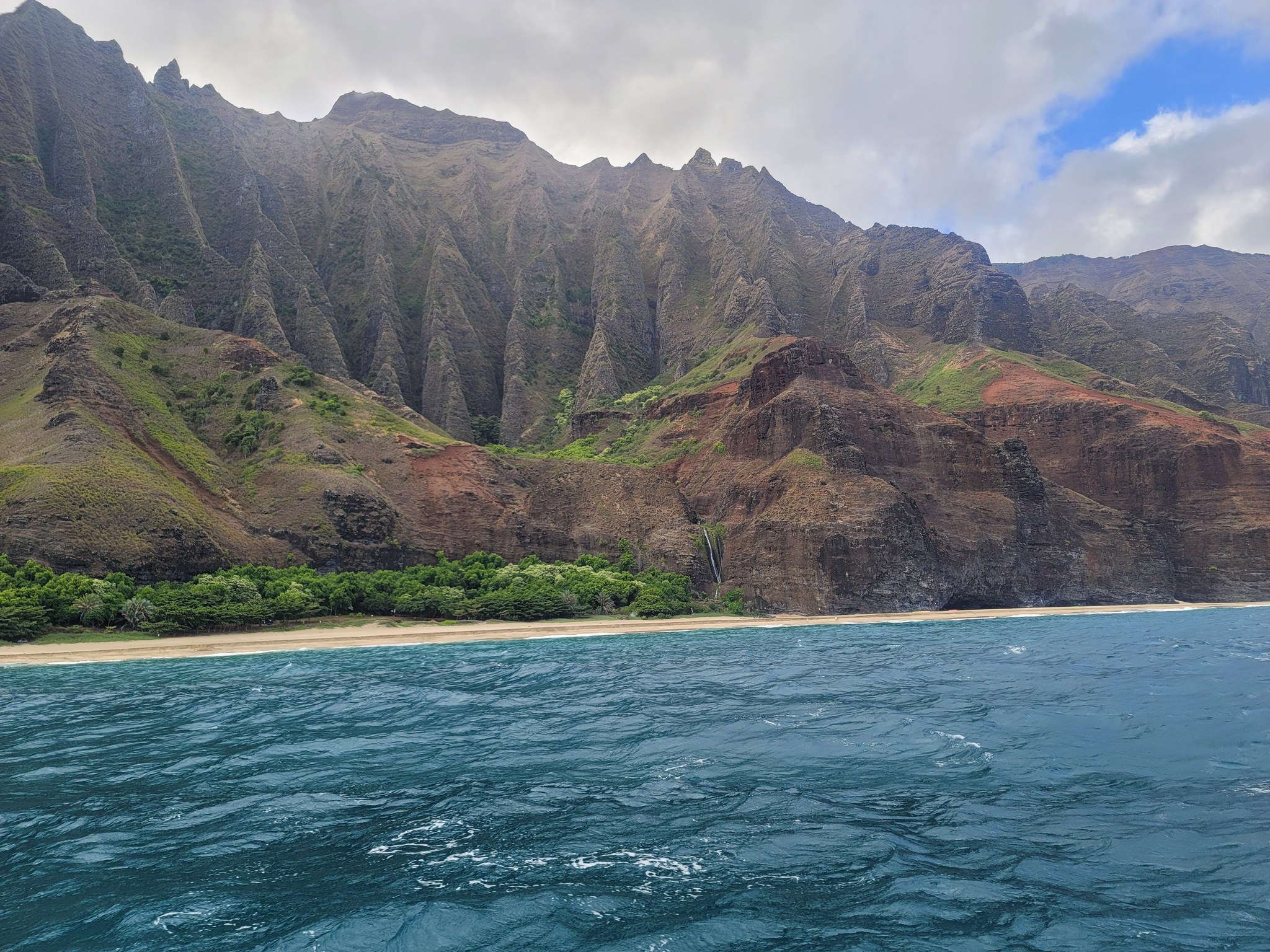 The Napali coastline from the water, sharp ridges dropping into the sea